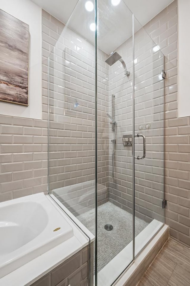 bathroom featuring a stall shower and a garden tub