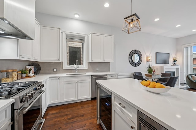 kitchen featuring wine cooler, premium range hood, a sink, light countertops, and appliances with stainless steel finishes