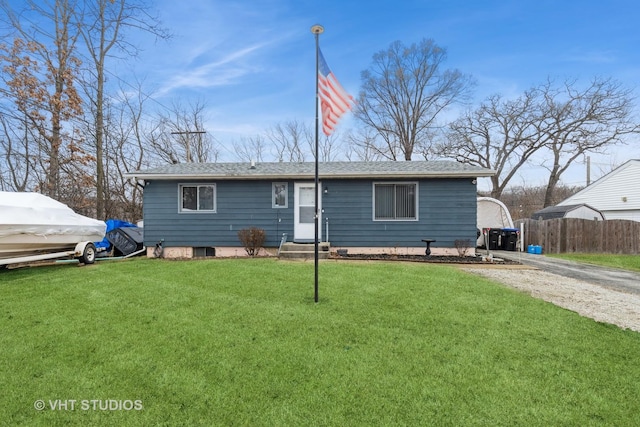 back of property with a yard, entry steps, gravel driveway, and fence