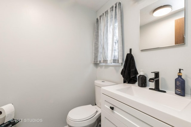 half bathroom featuring toilet and vanity