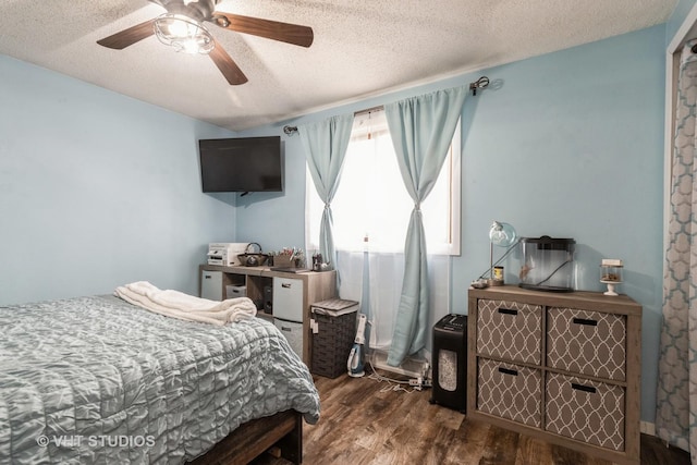 bedroom with dark wood-style flooring, ceiling fan, and a textured ceiling