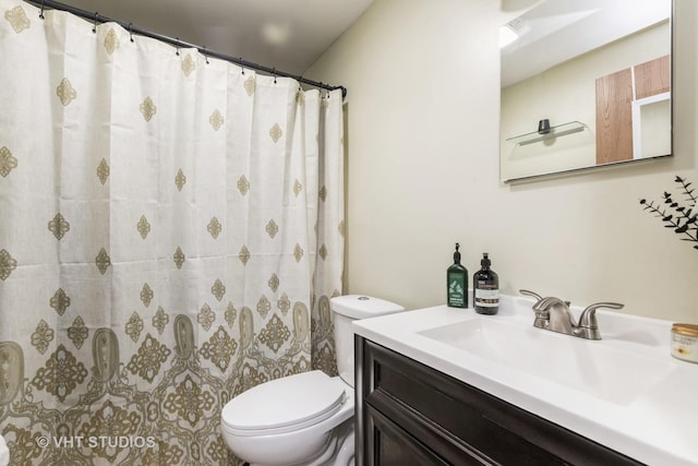 bathroom featuring a shower with shower curtain, vanity, and toilet