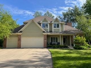 craftsman house featuring a garage, driveway, a porch, and a front lawn