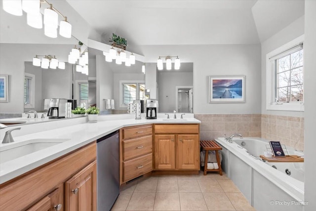 full bath with tile patterned flooring, a garden tub, a sink, vaulted ceiling, and double vanity