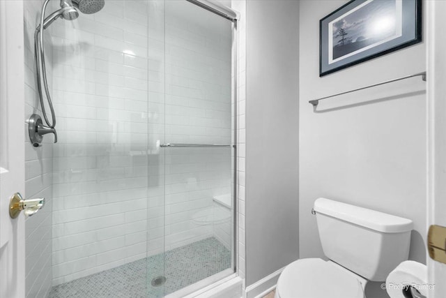 full bathroom featuring a stall shower and toilet