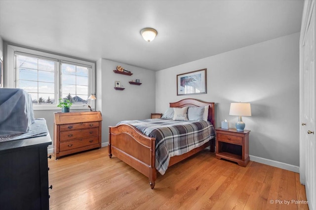 bedroom with light wood finished floors and baseboards