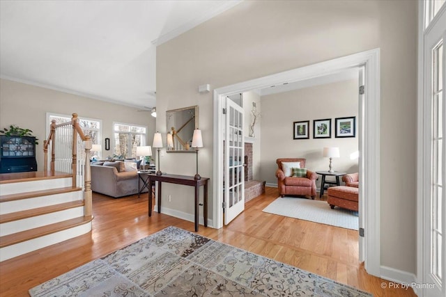 foyer entrance featuring stairs, baseboards, and wood finished floors