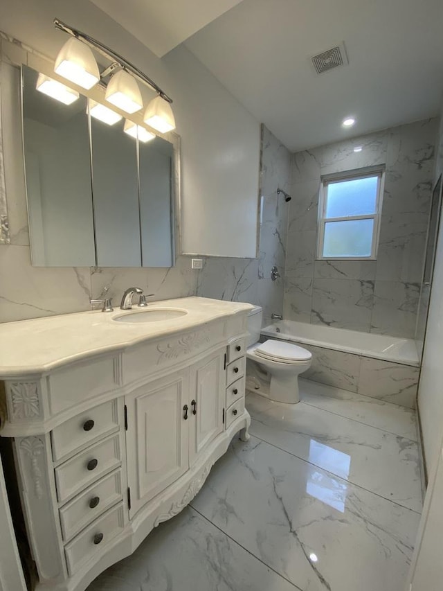 full bathroom with toilet, vanity, visible vents, marble finish floor, and washtub / shower combination