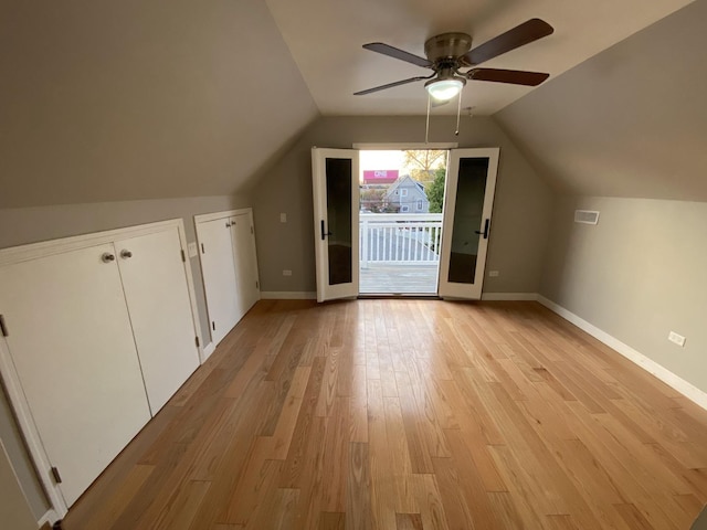 bonus room featuring lofted ceiling, light wood-style flooring, and baseboards