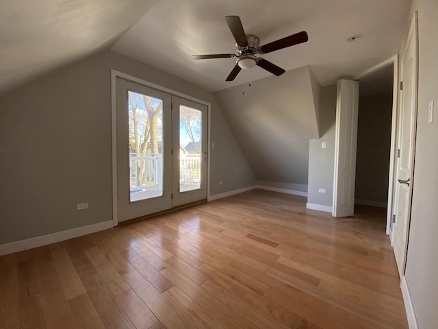 bonus room with light wood finished floors, ceiling fan, baseboards, and vaulted ceiling