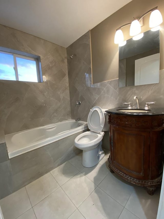 bathroom with toilet, shower / bathtub combination, tile patterned floors, vanity, and tile walls