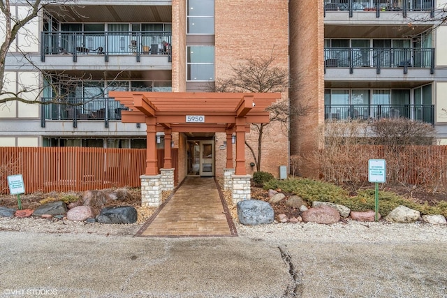 entrance to property with fence and brick siding