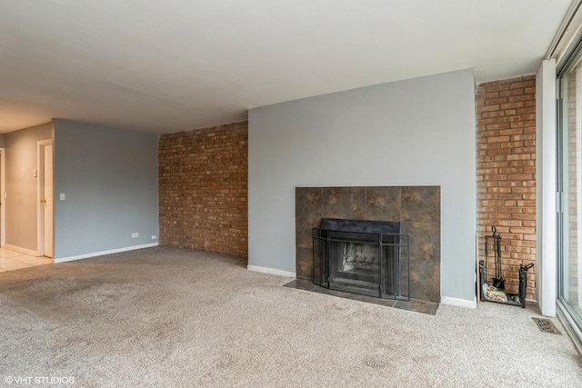 unfurnished living room featuring baseboards, carpet flooring, visible vents, and a tiled fireplace