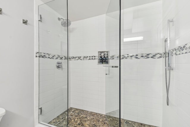 bathroom with toilet and a shower stall