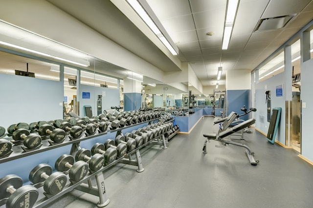 exercise room with a paneled ceiling and visible vents