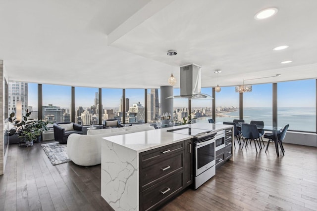 kitchen featuring stainless steel electric range oven, floor to ceiling windows, a view of city, and island range hood