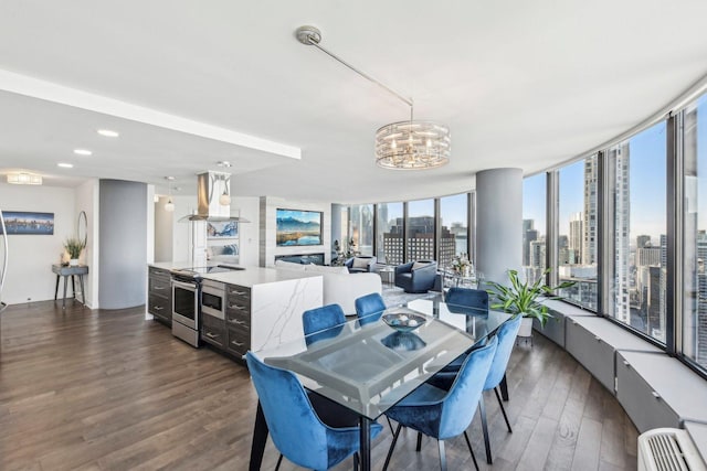 dining area featuring dark wood-style floors, a notable chandelier, and a city view