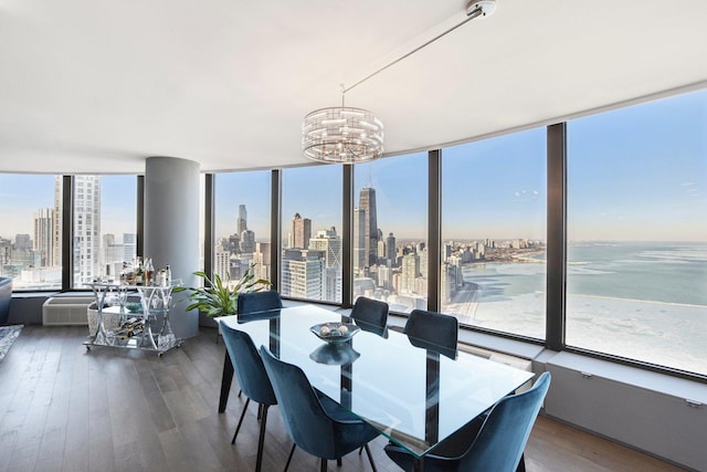 dining room featuring an inviting chandelier, dark wood-type flooring, a city view, and a wall of windows