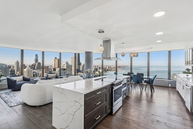 kitchen featuring electric range, island range hood, dark wood-style floors, light stone countertops, and a city view