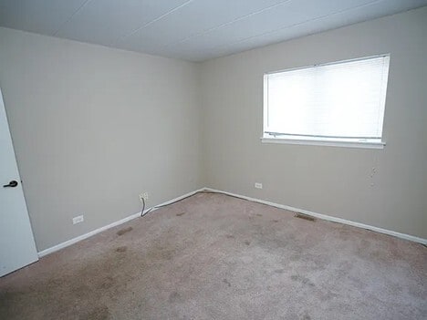 unfurnished room featuring carpet floors and baseboards