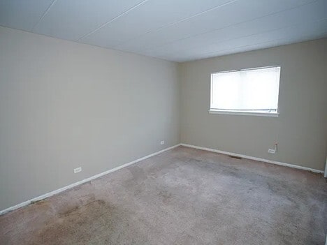 carpeted empty room featuring baseboards