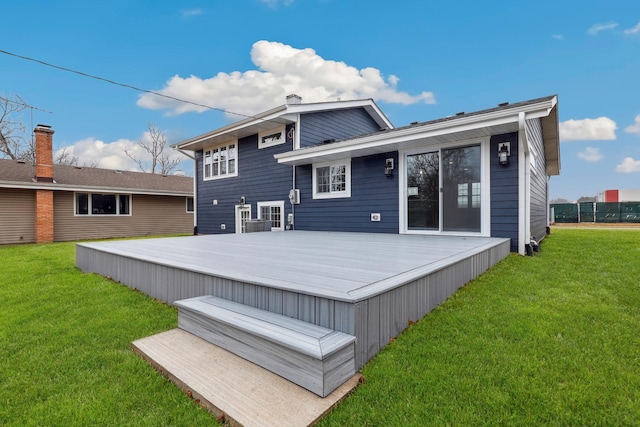 back of property with a lawn and a wooden deck