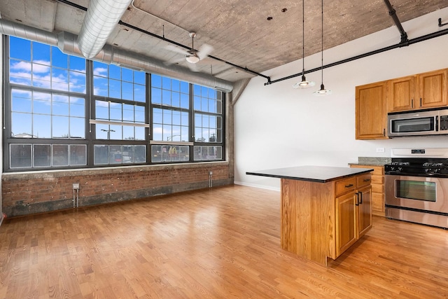 kitchen featuring light wood-style floors, a kitchen island, stainless steel appliances, and brown cabinetry