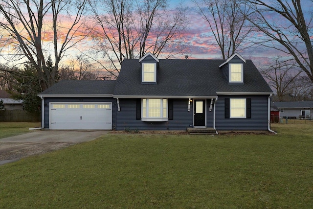 cape cod-style house featuring a shingled roof, fence, concrete driveway, a yard, and a garage