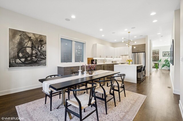 dining room featuring recessed lighting, an inviting chandelier, dark wood-type flooring, and baseboards