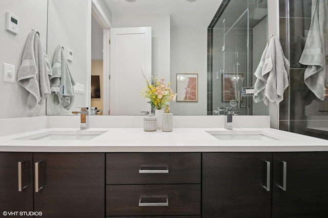 full bathroom with double vanity, a stall shower, and a sink