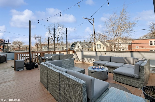 wooden terrace with an outdoor living space with a fire pit