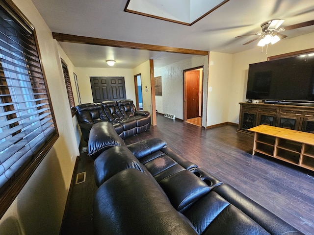 living area featuring visible vents, ceiling fan, baseboards, and wood finished floors