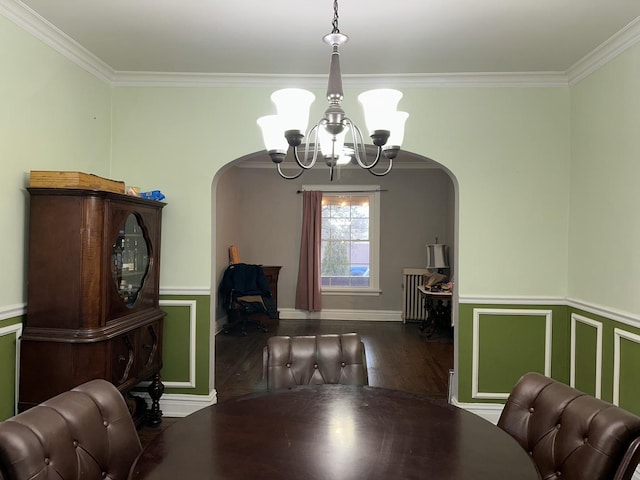 dining space with a notable chandelier, crown molding, arched walkways, and wood finished floors