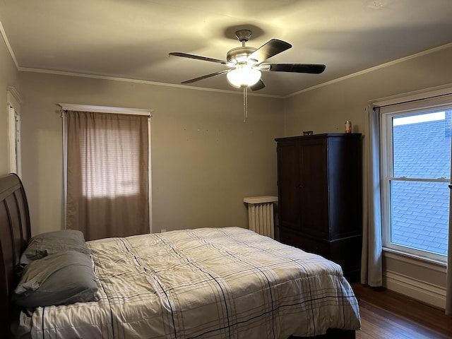 bedroom featuring ornamental molding, ceiling fan, baseboards, and wood finished floors