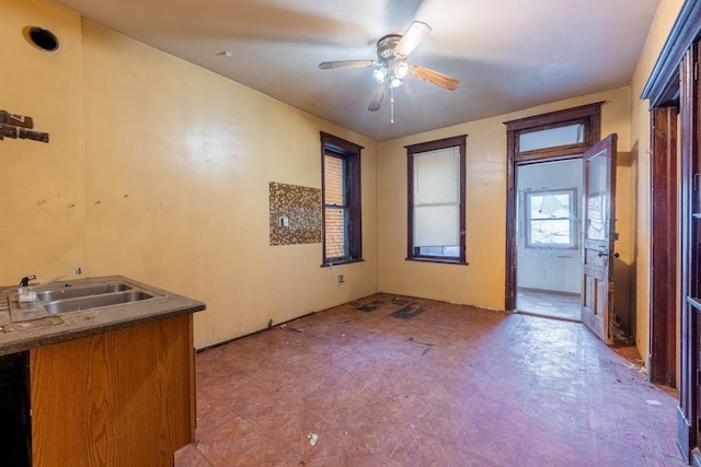 interior space with a sink, a ceiling fan, and tile patterned floors