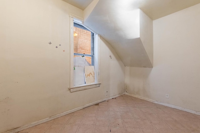 bonus room with lofted ceiling, baseboards, plenty of natural light, and light floors