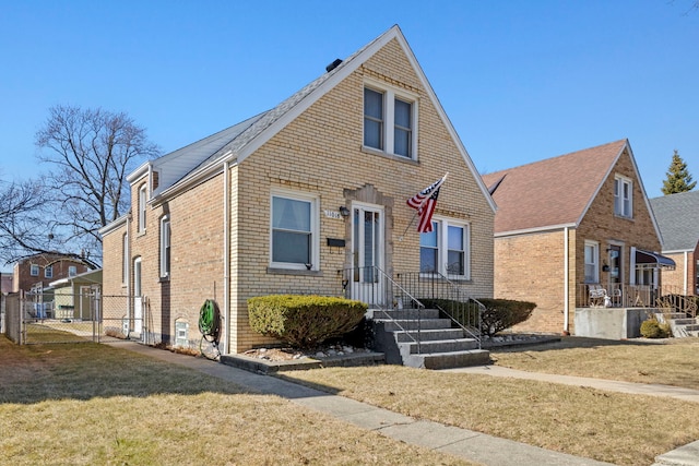 view of front of property featuring a front yard, a gate, brick siding, and fence