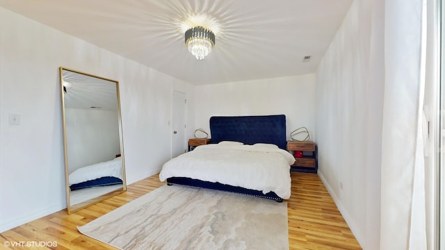 bedroom with light wood-style flooring, visible vents, and baseboards