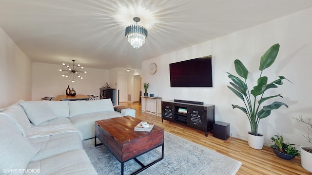 living area featuring wood finished floors, baseboards, and an inviting chandelier