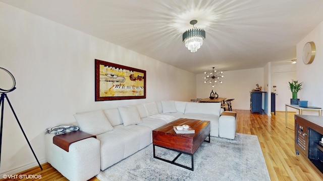 living room featuring light wood-style floors and an inviting chandelier