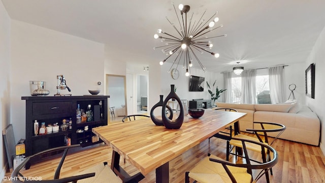 dining space featuring light wood-style floors and an inviting chandelier