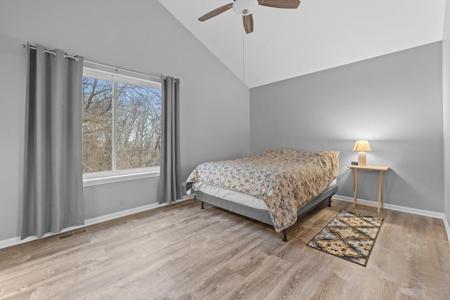 bedroom with visible vents, ceiling fan, wood finished floors, high vaulted ceiling, and baseboards