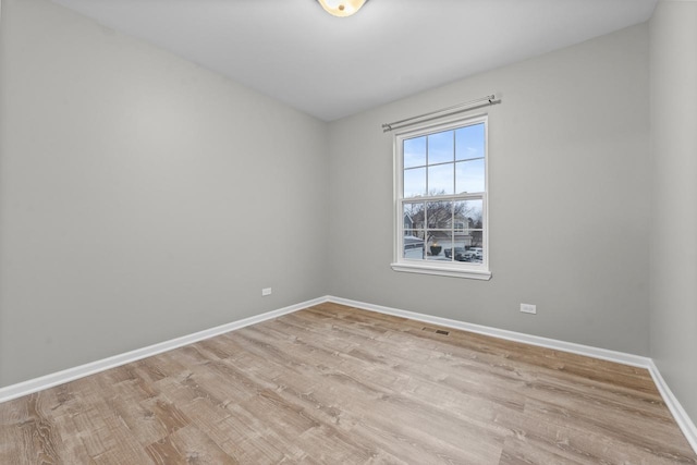 spare room featuring light wood-style flooring and baseboards