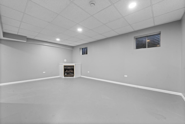 finished basement with recessed lighting, a drop ceiling, and baseboards