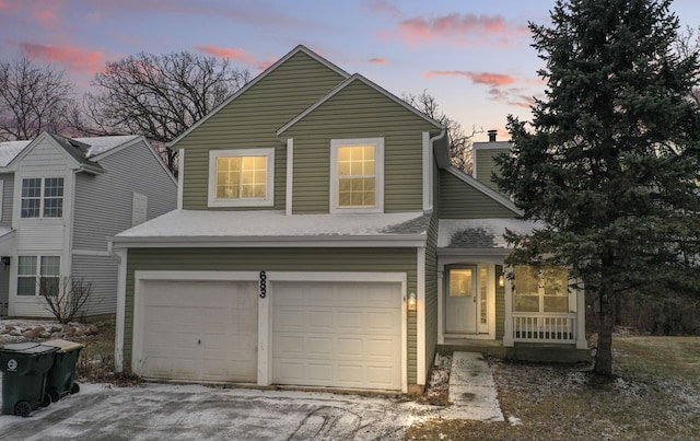 traditional home featuring a garage and roof with shingles