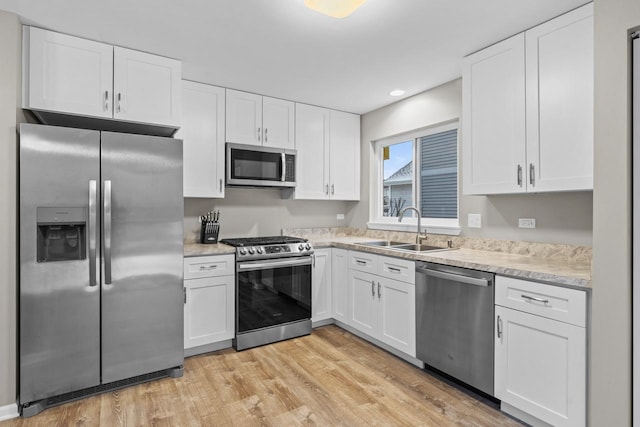 kitchen featuring light countertops, appliances with stainless steel finishes, a sink, and white cabinetry