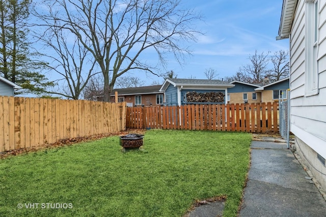 view of yard with fence and a fire pit