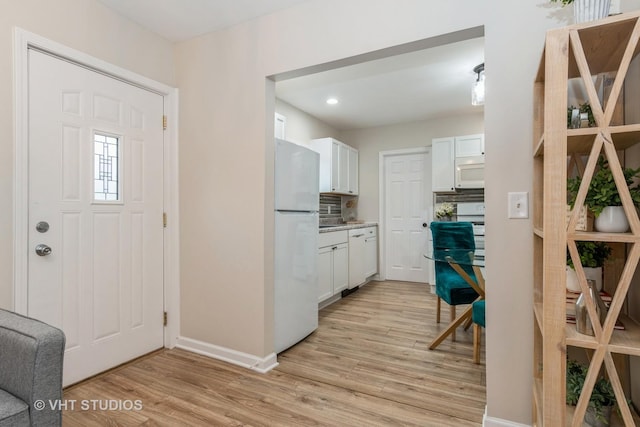 foyer entrance featuring light wood-style floors, baseboards, and recessed lighting