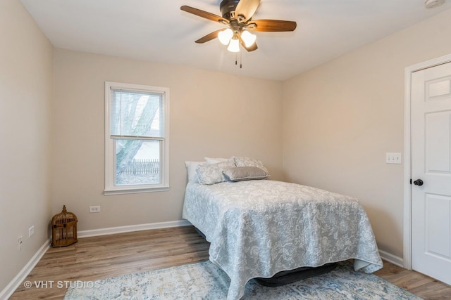 bedroom featuring ceiling fan, baseboards, and wood finished floors