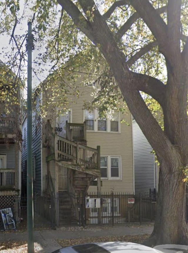 view of front of property featuring fence and stairway